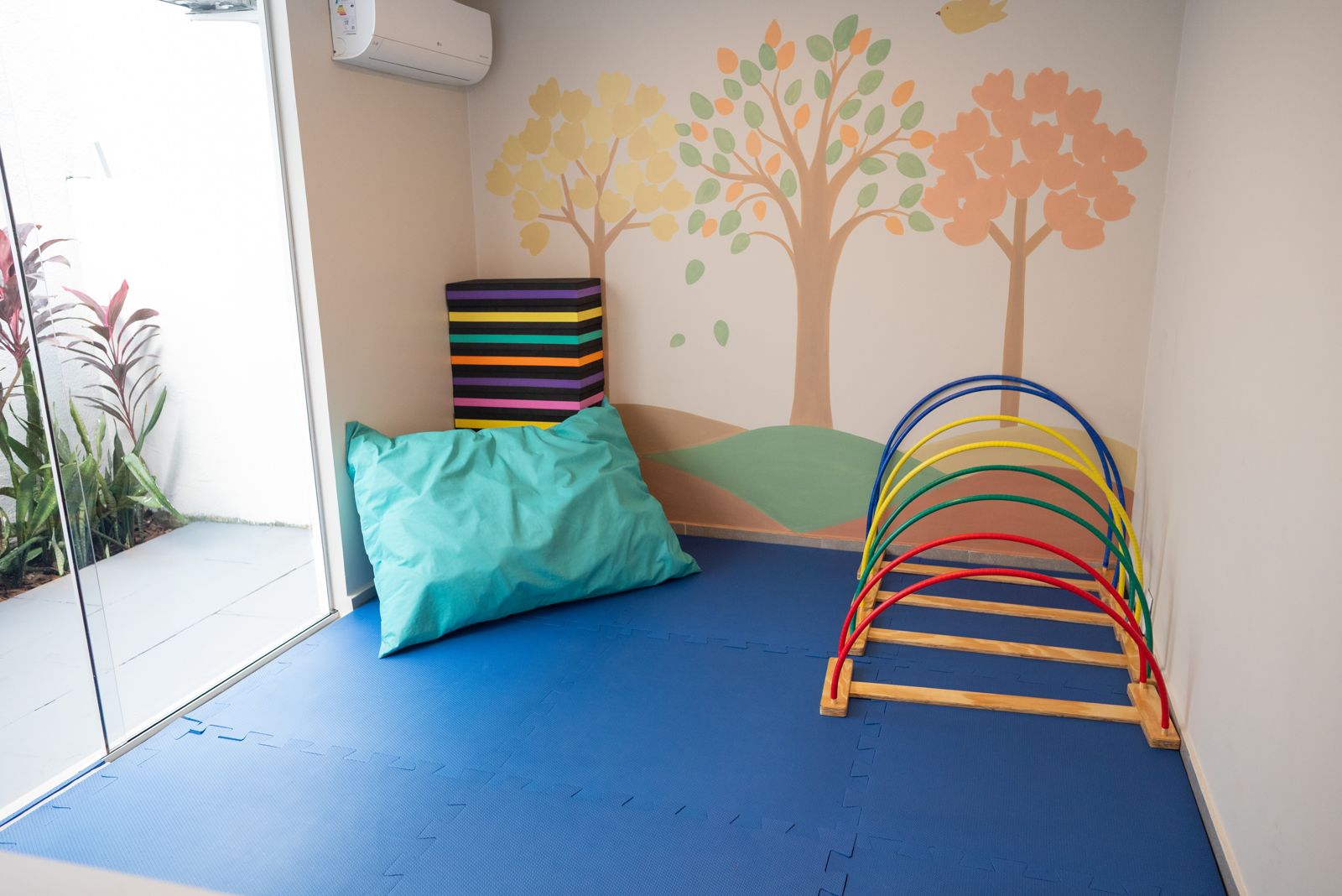 Sala sensorial com mural e almofadas